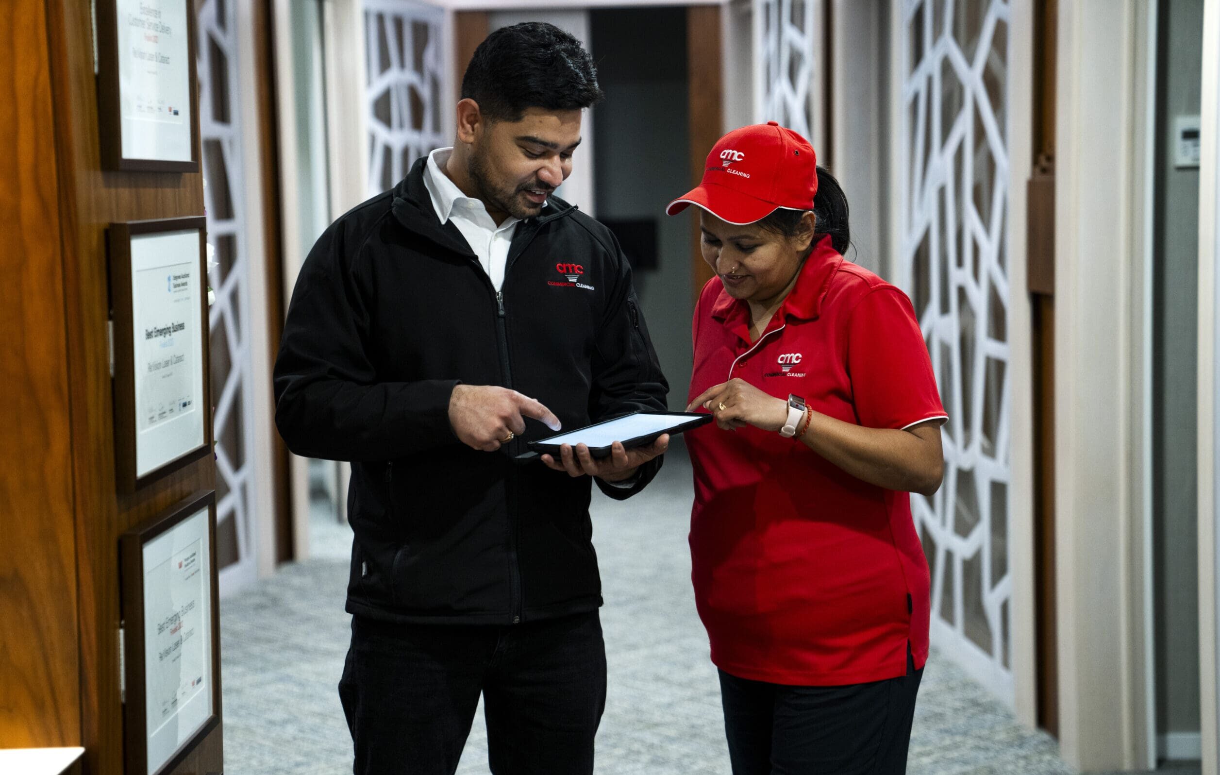 amc commercial cleaning supervisor and cleaner reviewing the commercial cleaning scope of work to increase efficiency for the client and benchmark performance against KPIs set at the start of the contract 