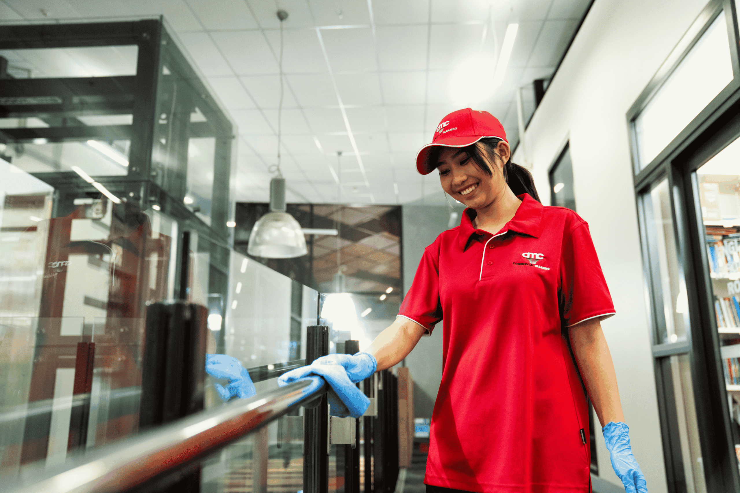 Professional commercial cleaner in red uniform assessing workplace cleaning quality during a service review.
